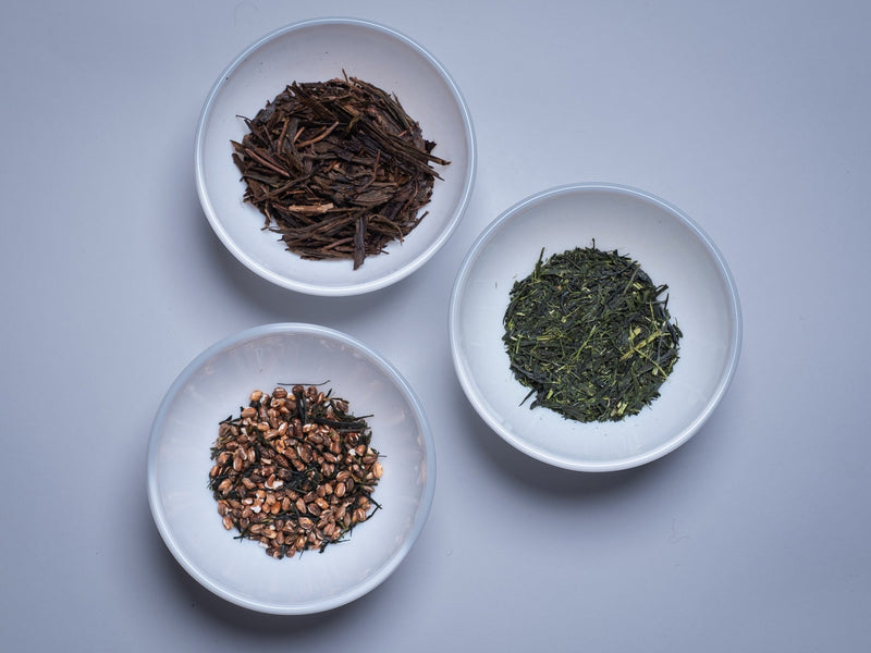 Hojicha, genmaicha and green tea leaf in three white dishes